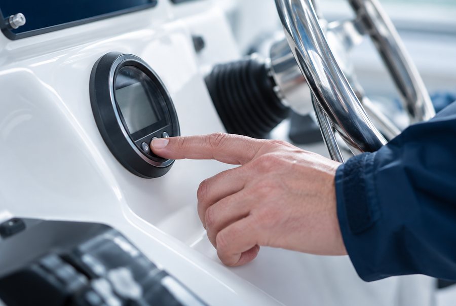 Hand bedient een instrument in de kuip van een boot