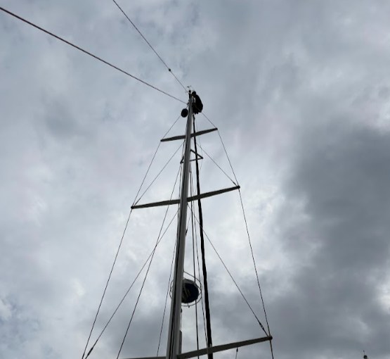 Monteur werkt in de mast van een zeiljacht